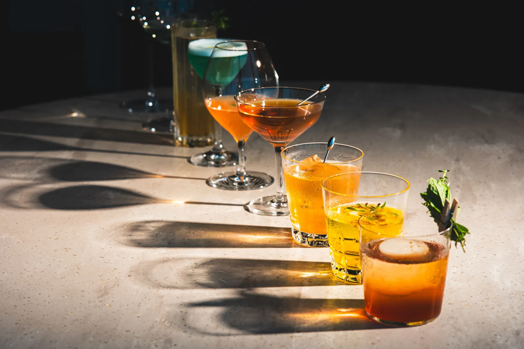 A row of colorful zero-proof cocktails on a marble table